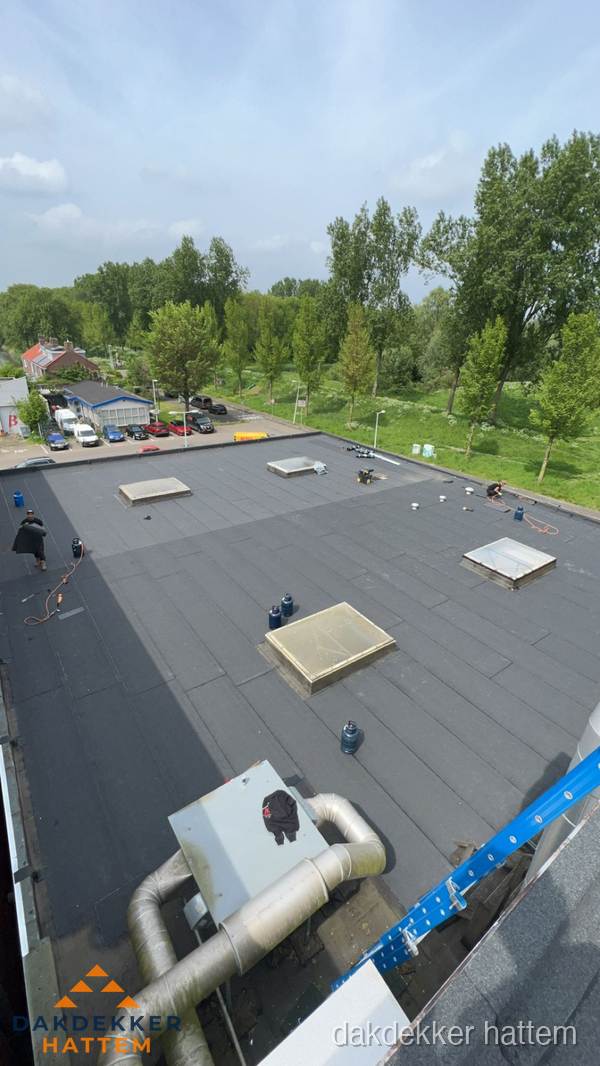 Dakdekker aan het werk op groot plat dak met bitumen in Hattem Dakdekker aan het werk op groot plat dak met bitumen in Hattem