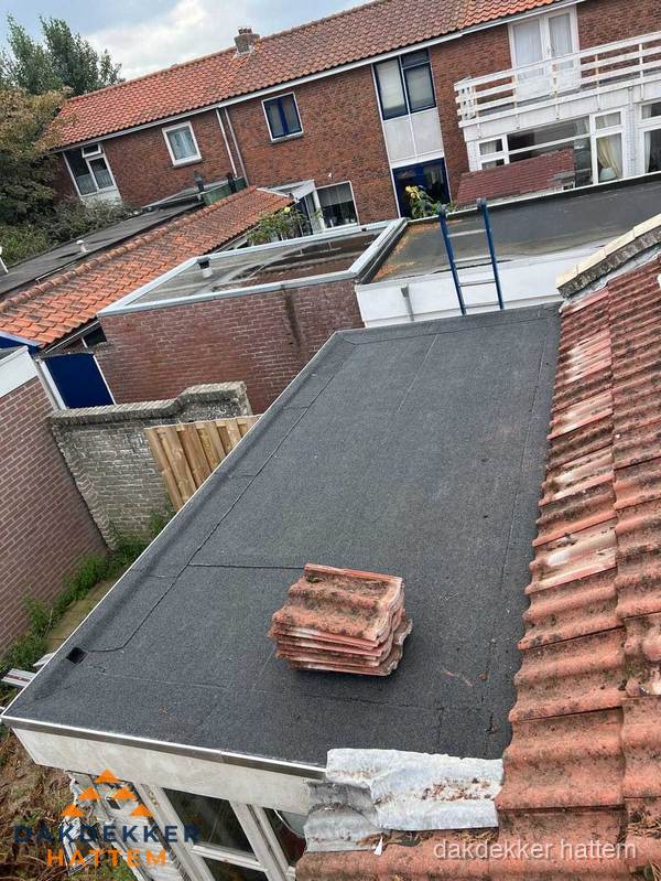 Plat dak aanbouw met bitumen naast schuin pannendak in Hattem Plat dak aanbouw met bitumen naast schuin pannendak in Hattem
